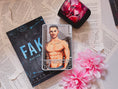 Load image into Gallery viewer, A grey Tarot Card titled "The Musician" with the image of a shirtless man on it, on top of a book titled Fake by Tate James with flowers, book pages, and a candle in the background.