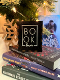 Load image into Gallery viewer, Black box with "Book Lover" printed on them. Bookstack and Christmas tree in the background.