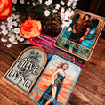 Load image into Gallery viewer, Collection of tarot cards on a wooden surface with flowers and a decorative sign.