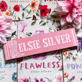 Load image into Gallery viewer, Wooden sign with Elsie Silver and a boot printed on it. Books and flowers in the background.