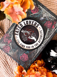 Load image into Gallery viewer, Fated Lovers Round featuring a romantic and mystical design. Held sideways. Wooden Sign with a black frame and a white inner circle with text that says 'Fated Lovers' and "I'll Find You in the Afterlife". UV printed purple background with design of a skeletal hand reaching for a human one, over a heart with roses. FireDrake Artistry 2025
