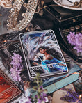 Load image into Gallery viewer, A 'Moonplume' Tarot Card featuring an illustration of a dragon ad a woman, placed next to the book 'When the Moon Hatched' by Sarah A. Parker, with a decorative background.