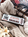 Load image into Gallery viewer, Fall Book Festival Ticket Sign. Thick Wooden sign with a white background shaped like a ticket. Orange text that reads “Fall Book Festival” with a date and ticket details. Featuring an image of witches, which beneath reads “witches welcome”. ©️FireDrake Artistry 2025