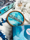 Load image into Gallery viewer, Round wooden sign with 'MOONBEAM' text and dragon design with white and blue background.