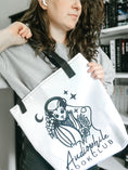 Load image into Gallery viewer, Audiophile Bookclub White Tote Bag from FireDrake Artistry™. Photo by @athousandbookishlives