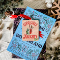 Load image into Gallery viewer, A rectangular wooden ornament featuring a Christmas tree of books next to a girl in a Santa hat tied up with Christmas lights surrounded by text that reads 'Good Girls Naughty List'. © FireDrake Artistry 2023
