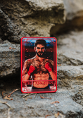 Load image into Gallery viewer, A red Tarot Card titled "The Archer" with the image of a shirtless man on it, on top of a stone step