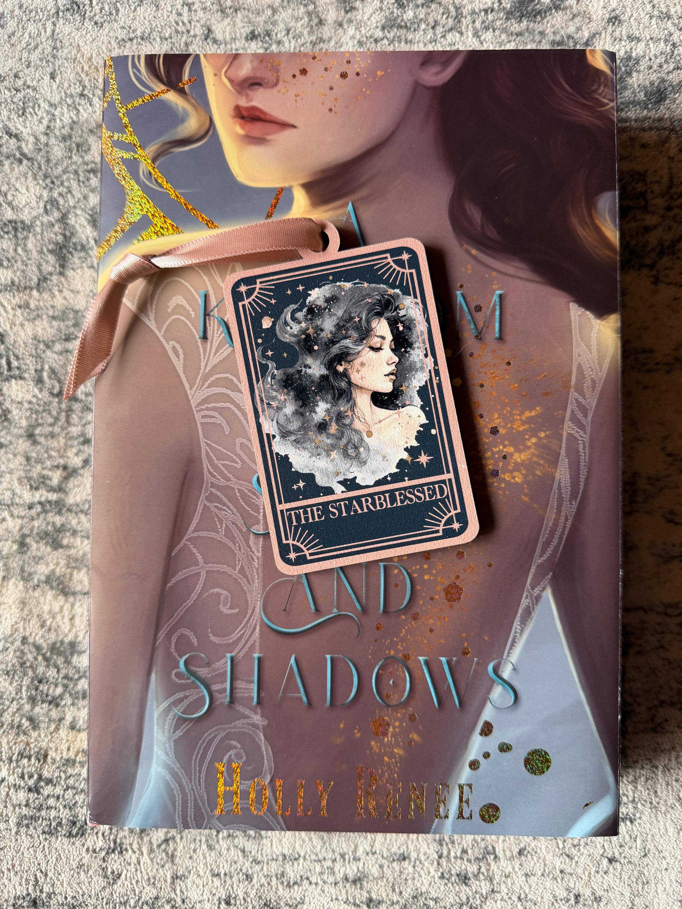 Tarot Card ornament titled "The Starblessed" with  pink ribbon and book underneath.