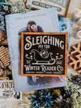 Load image into Gallery viewer, Wooden shelf sign with a black background and woodgrain frame.  A white sleigh with presents, surrounded by white text reading  'Sleighing My TBR' and "Winter Reader Co. EST 2025." © FireDrake Artistry 2025

