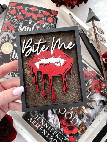 Bite Me Shelf Sign - FireDrake Artistry™ wooden sign with natural background, dark grey frams, white "Bite Me" wording and red vampire lips. 