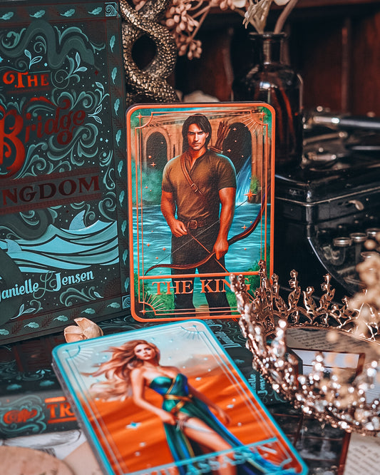 Tarot cards with 'The King' and 'The Queen' on a mystical table setting.