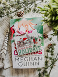 Load image into Gallery viewer, Wooden ornament with a white background. Graphic features a gingerbread train pulling a stack of books with other Christmas items with text below that reads "Booked for the Holidays". © FireDrake Artistry 2024
