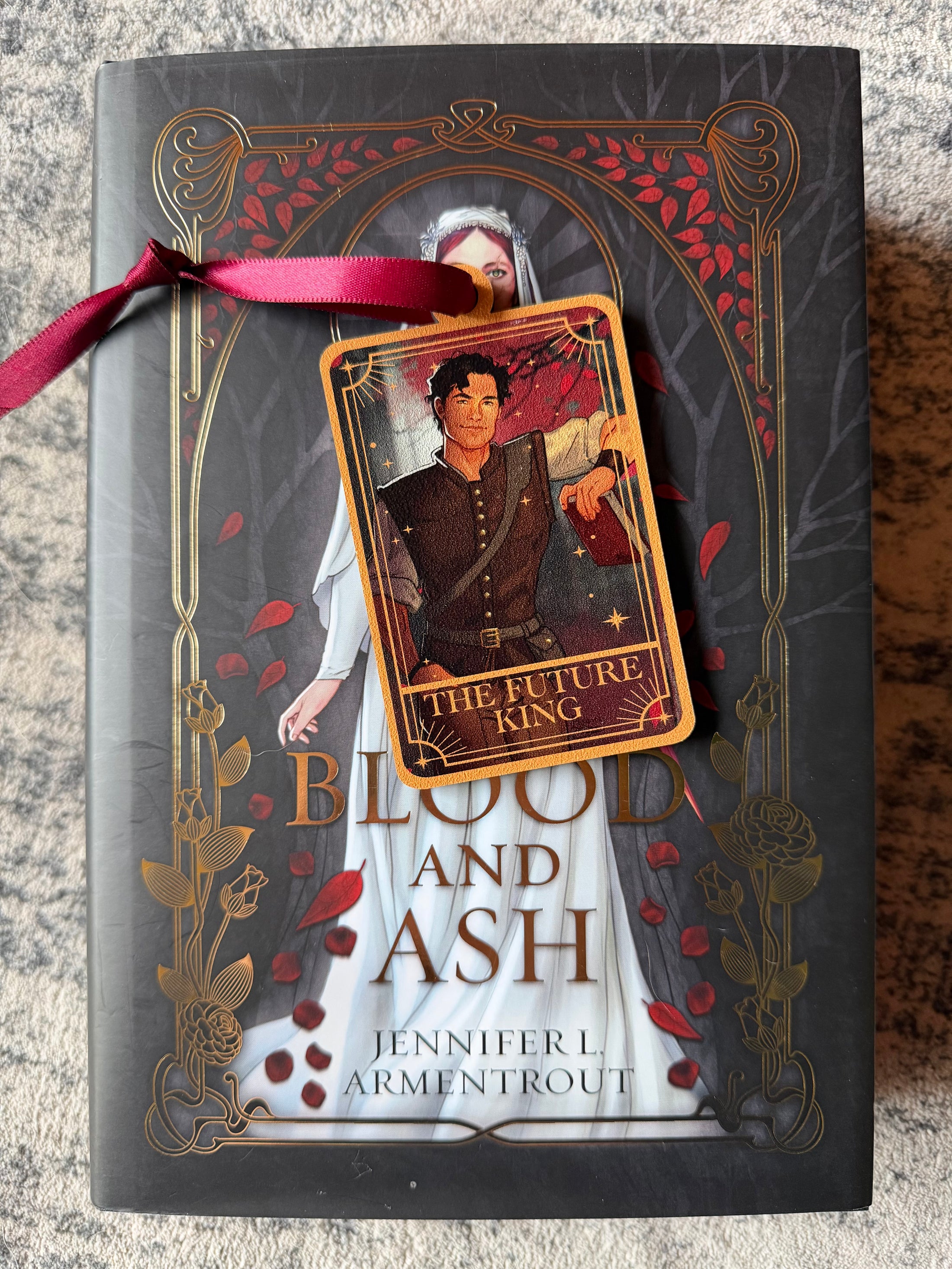 Tarot Card ornament titled "The Future King" with  maroon ribbon and book underneath.