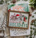 Load image into Gallery viewer, Wooden sign with a white background and woodgrain frame. Graphic features a gingerbread train pulling a stack of books with other Christmas items with text below that reads "Booked for the Holidays". © FireDrake Artistry 2024
