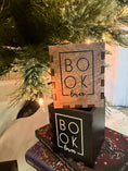 Load image into Gallery viewer, Wooden and black boxes with "Book Lover" printed on them. Bookstack and Christmas tree in the background. 
