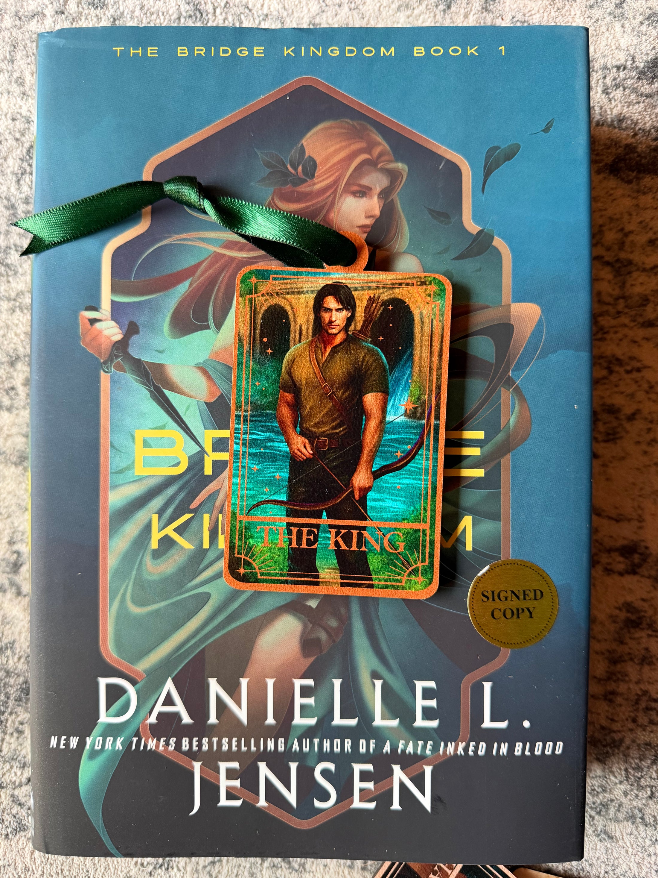 Tarot Card ornament titled "The King" with  green ribbon and book underneath.