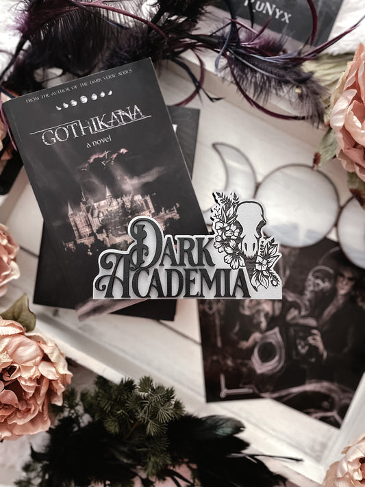Dark Academia Sign. Grey wooden block sign with 3D text that reads "DARK ACADEMIA" beside a skull and flowers. 