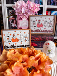 Load image into Gallery viewer, Tis the Season Ghosts Sign - Orange & Pink Fall versions. A decorative wooden sign featuring hand painted and UV-printed cartoon ghosts, pumpkins, and the phrase 'tis the season'. FireDrake Artistry 2024
