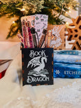 Load image into Gallery viewer, Wooden box with 'Book Dragon' design on top of books with a Christmas tree in the background
