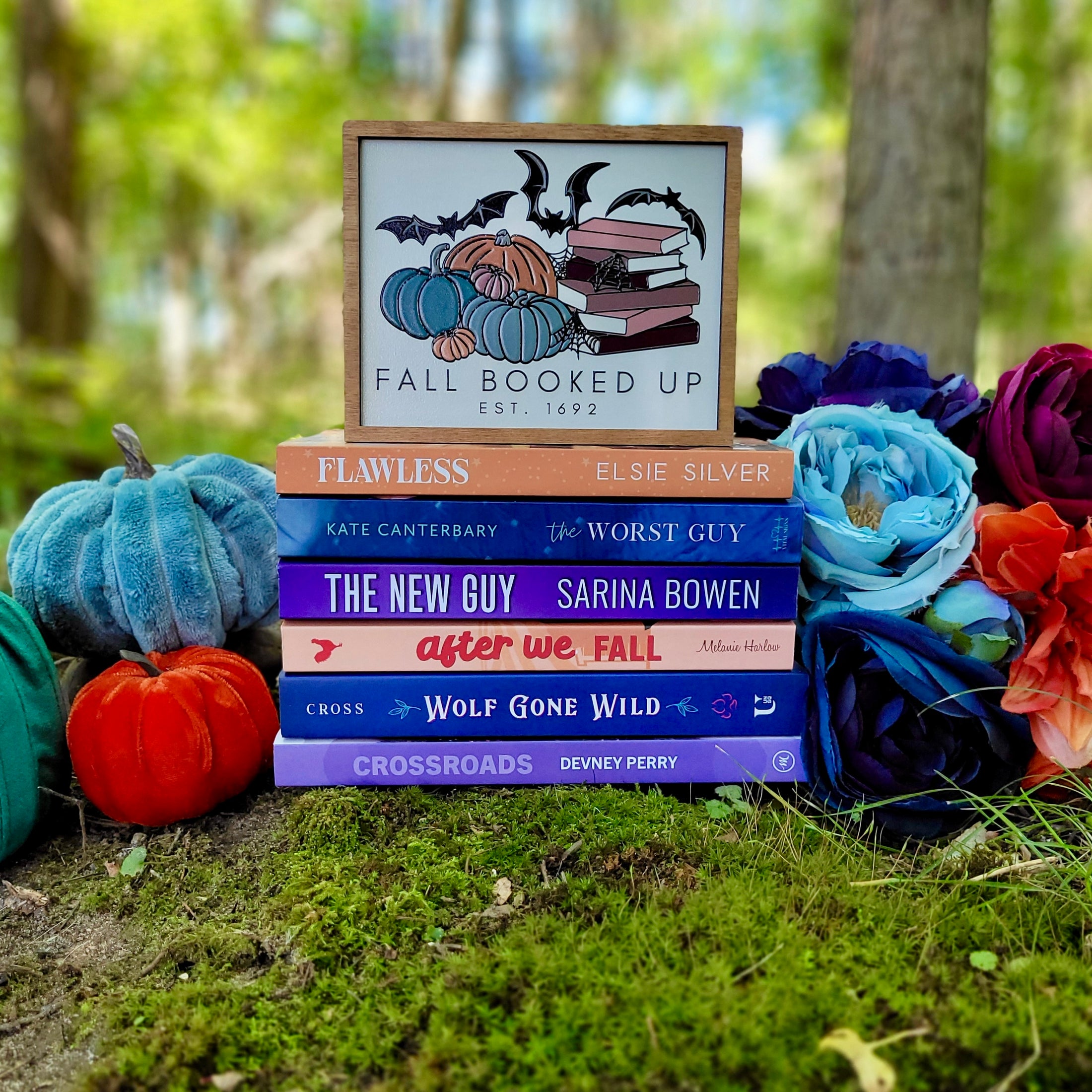 Fall Booked Up Sign - Multicolor Version- ©️ Fire Drake Artistry 2025. Wooden sign with white background and wood stained frame, UV printed design with a cluster of pumpkins beside a stack of books and bats flying around. 