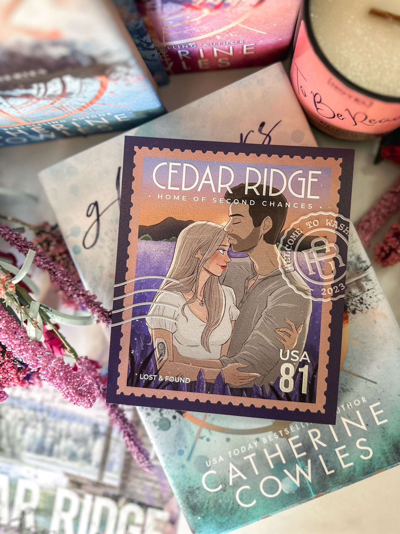 A postage stamp featuring artwork of a romantic scene, on top of a stack of books with a book stack and candle in the background. 