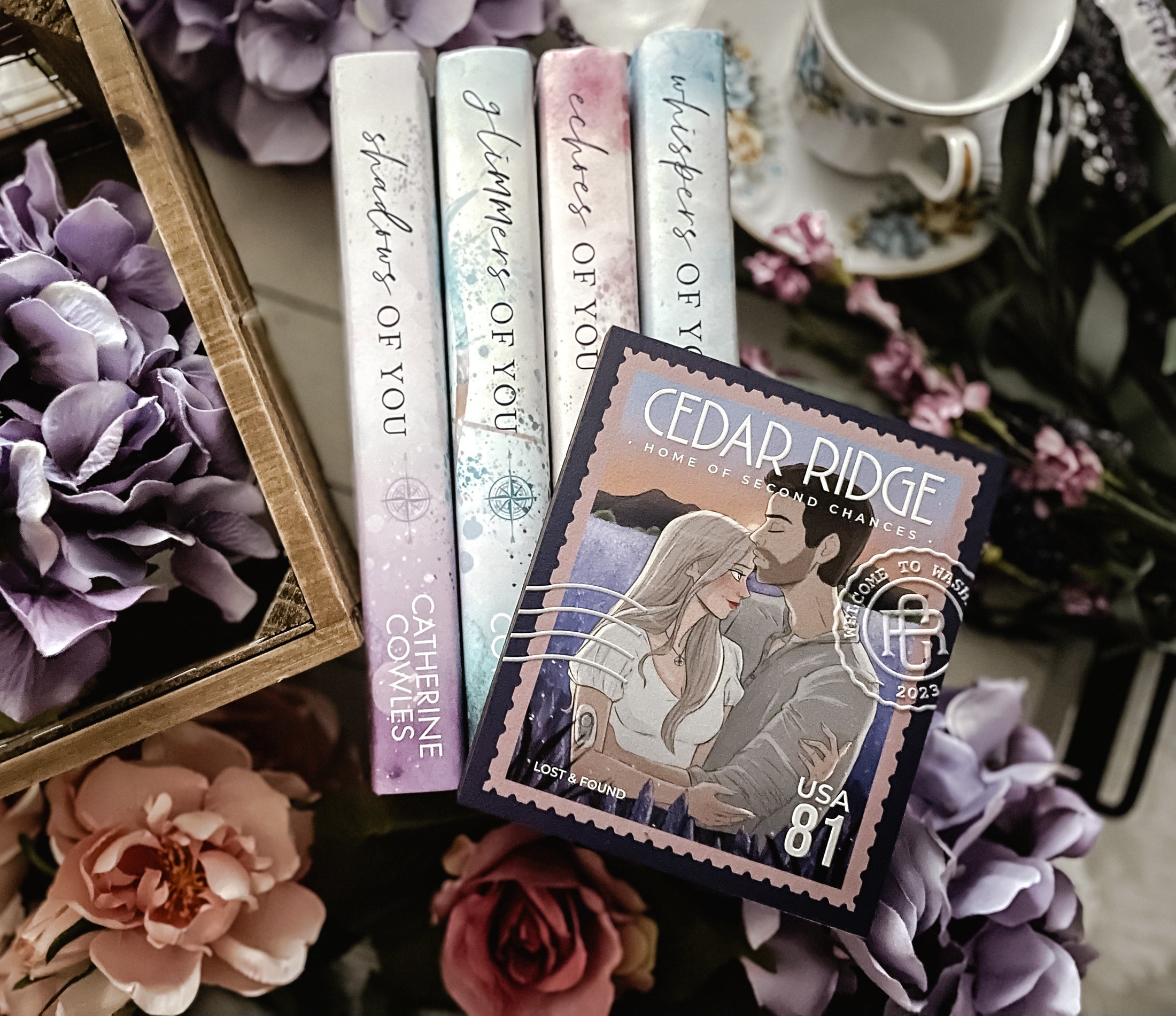 A postage stamp featuring artwork of a romantic scene, on top of a stack of books with a book stack and tea cup and flowers in the background. 