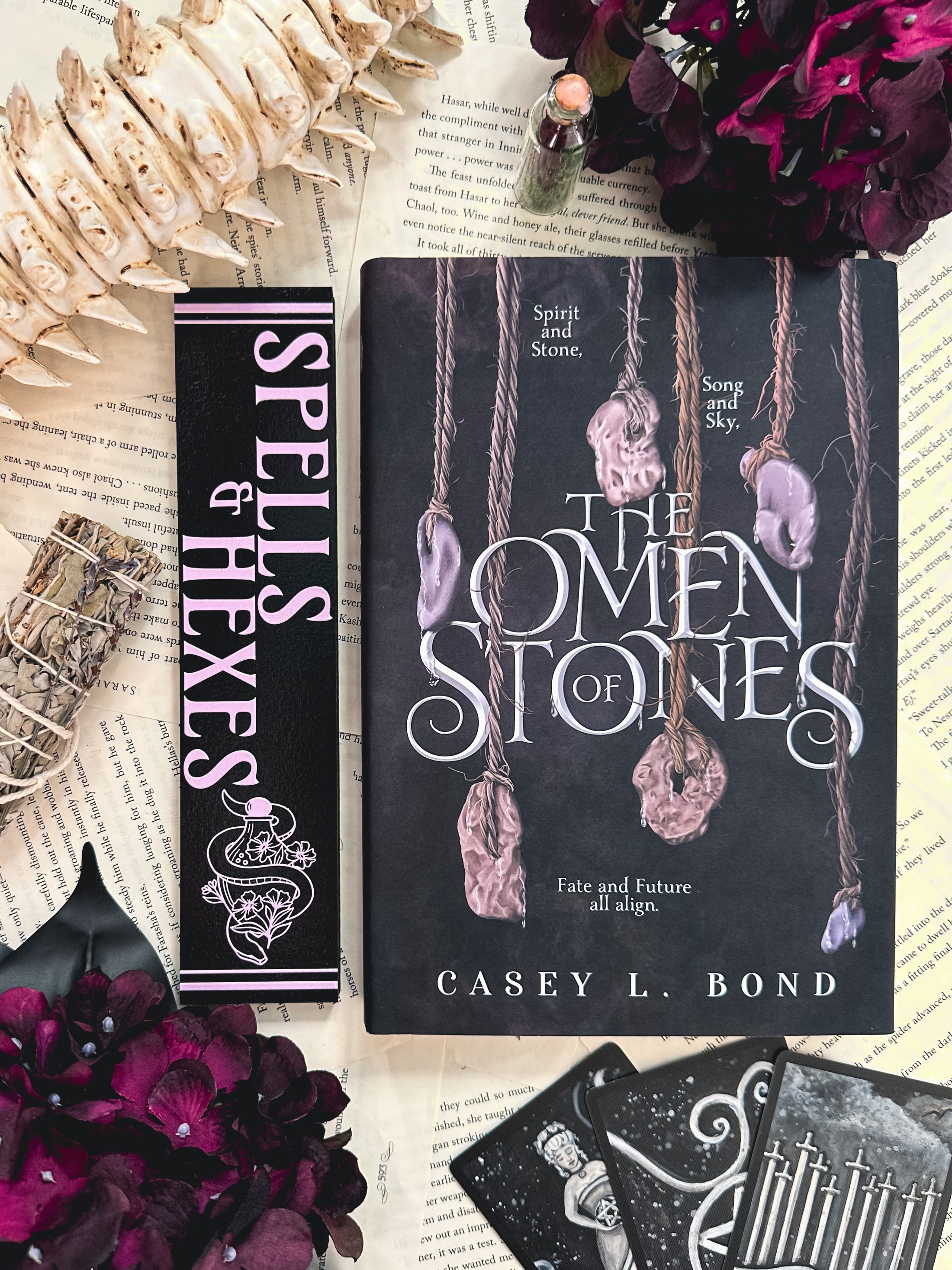 Spells & Hexes Shelf Mark™ by FireDrake Artistry® 2024. Black wooden shelf sitter with vertical purple UV printed text that reads SPELLS & HEXES" to the left of a snake around a vile with flowers. 