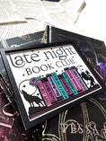 Load image into Gallery viewer, Late Night Book Club Sign. A white wooden shelf sign with a black border. UV printed design that reads "LATE NIGHT BOOK CLUB" above an assortment of books with a wolf and dragon bookends. 2024 FireDrake Artistry®
